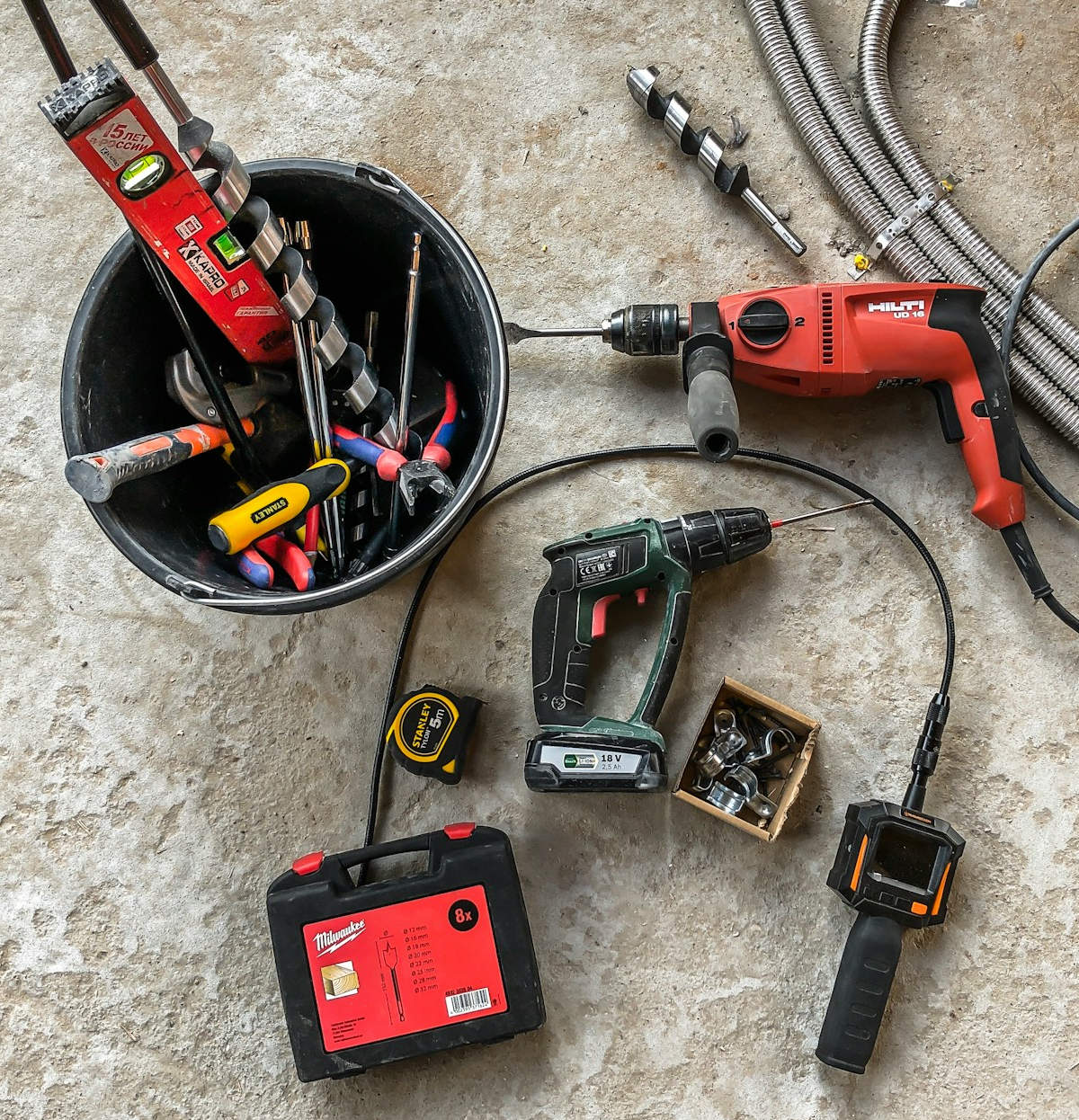 Various electric and gasoline-powered hand tools and construction machinery on the construction site.